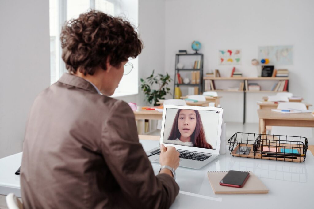 Person at a desk taking part in a live online lesson on a laptop